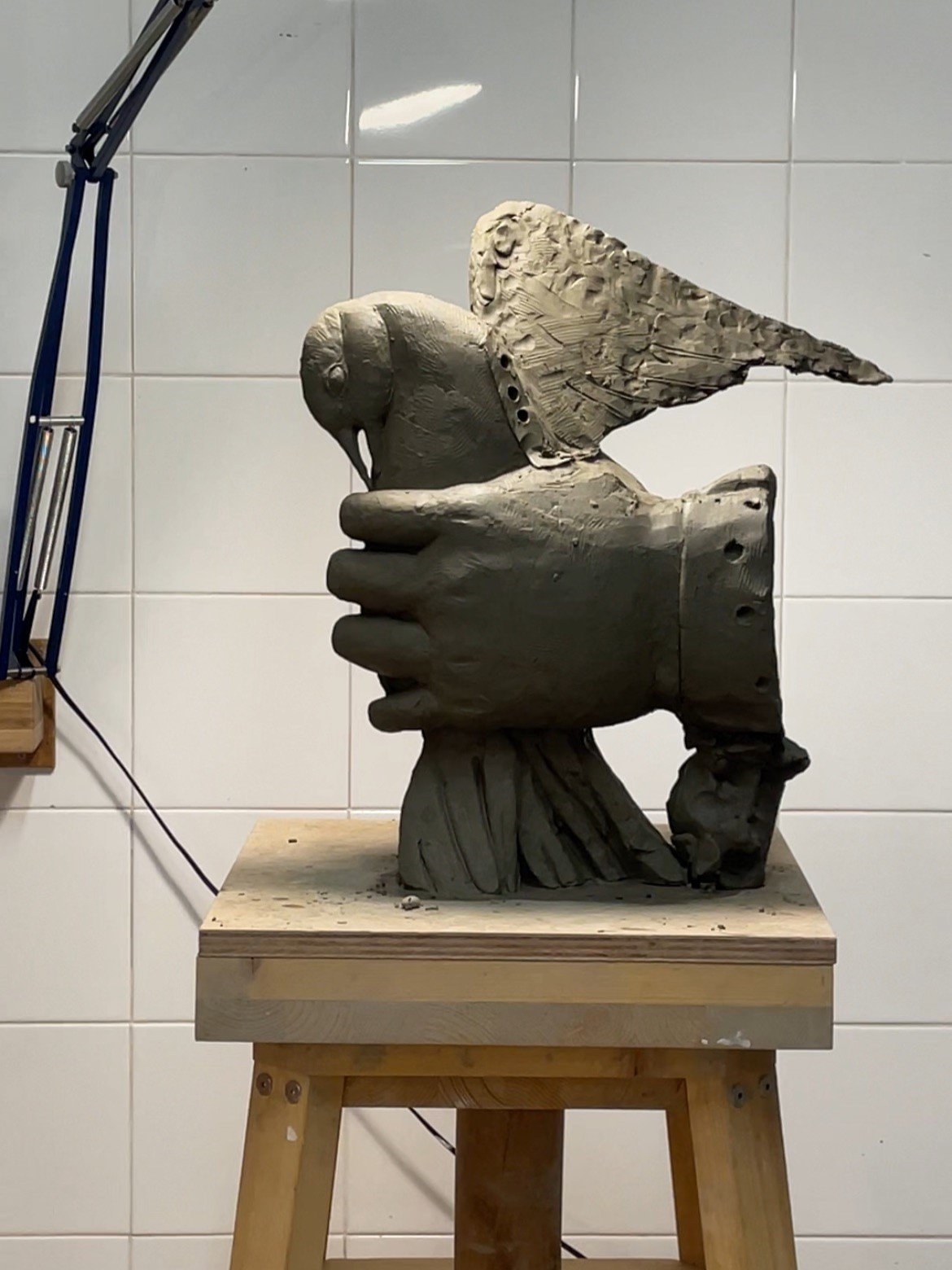 Scultura in ceramica di grandi dimensioni realizzata durante il corso a Milano, dettaglio di mani che sorreggono un uccello scolpito